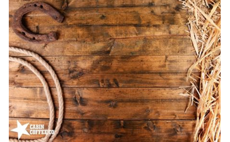 Wood background with hay, horseshoe, and rope.