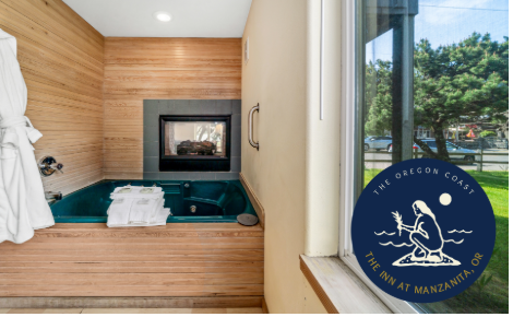 A large soaking tub next to a fireplace and beautiful wood clad walls. There is a logo tor The Inn at Manzanita in the bottom right corner.