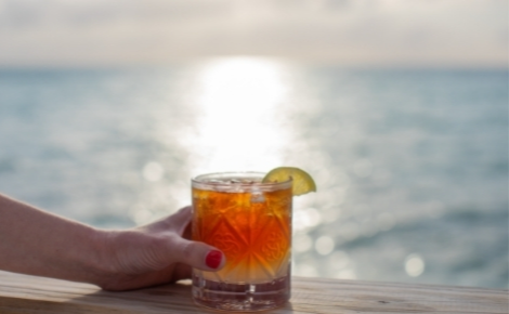 Gift card image of a cocktail with the sea in the background